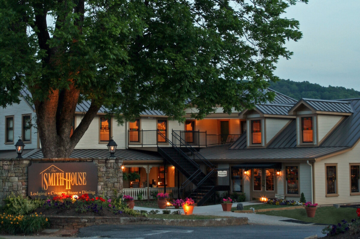 5 Destinations Where Southern Charm Thrives - 4 Two-story inn with a metal roof and outdoor staircase, lit warmly at dusk.