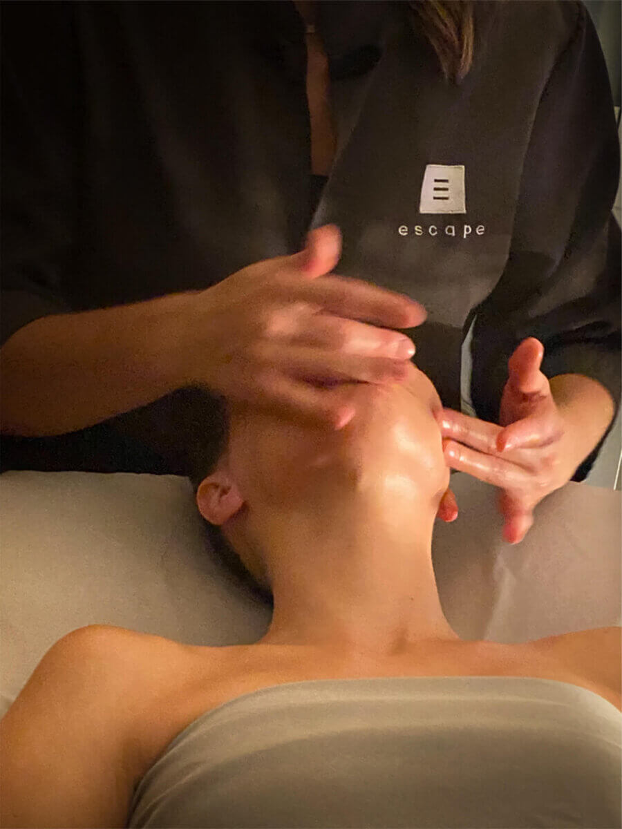 A person receives a relaxing facial massage while lying on a spa table, enjoying the benefits of expert massage therapy.