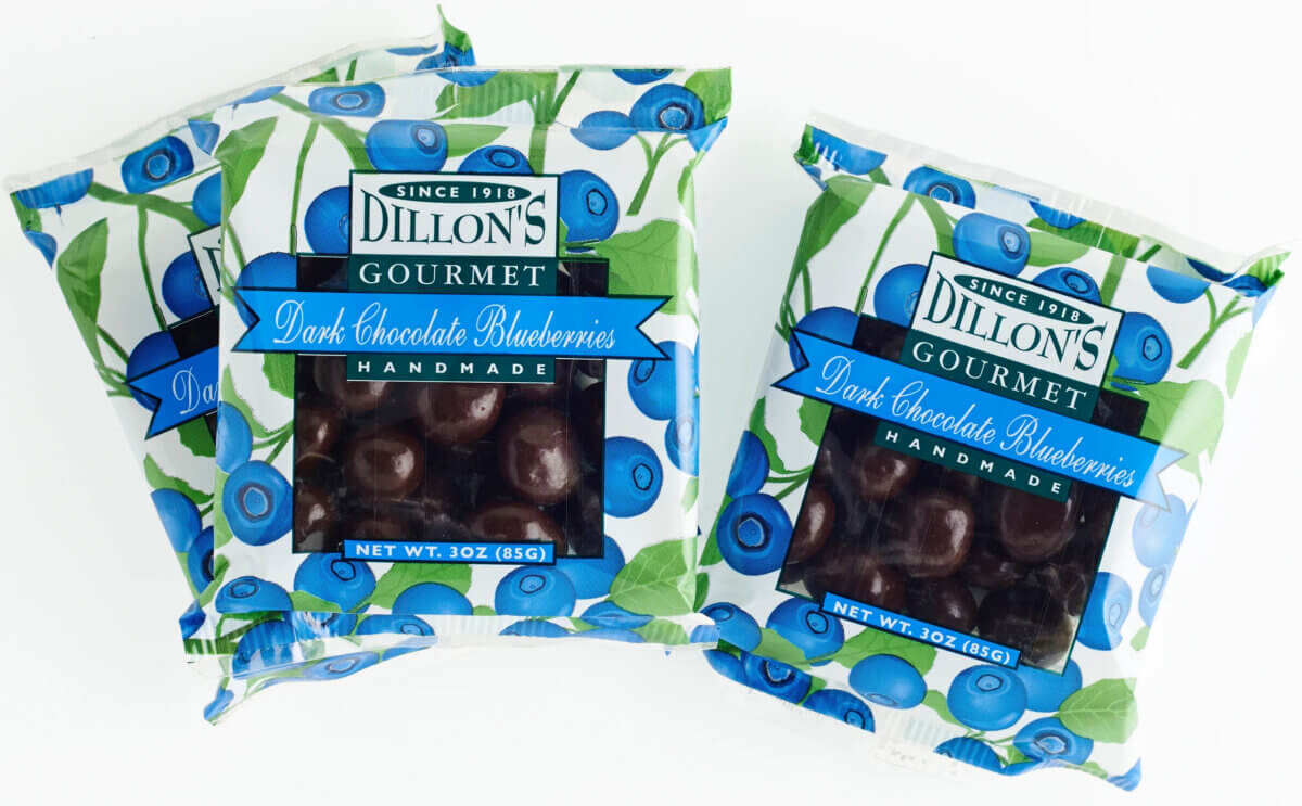 10 Grown-Up Halloween Candies We’re Keeping for Ourselves - 6 Three bags of Dillon’s Gourmet Dark Chocolate Blueberries, each weighing 3 ounces, are arranged on a white background—an elegant addition to your gourmet Halloween candy spread or the perfect treat for any grown-up guide to Halloween candy delights.