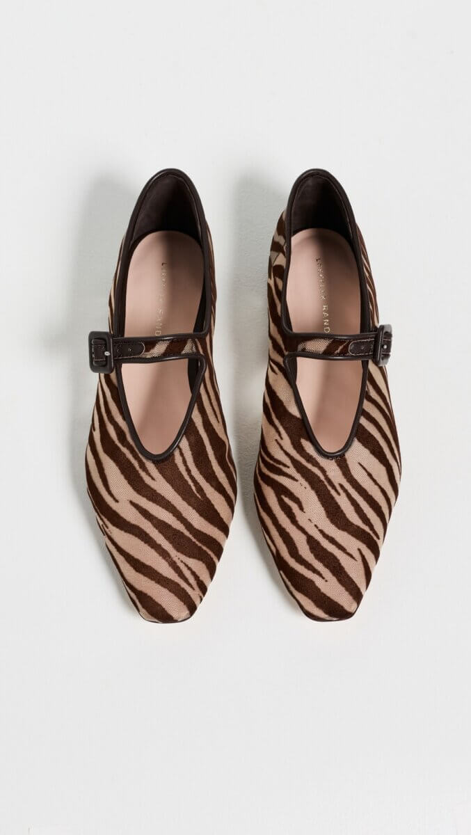 Fall Is Getting Wild: Animal Prints Are Back! - 15 Pair of brown and beige zebra-print Mary Jane shoes with black straps, photographed from above on a white background—a chic addition for fall fashion lovers who adore animal prints.
