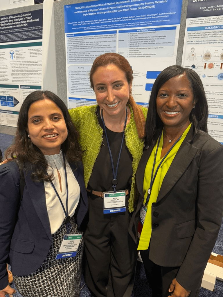 This BHAM Doctor Fights for Women's Lives Every Day - 5 Three women stand smiling in front of a scientific research poster at a conference, each wearing professional attire and conference badges. Their presence highlights the pivotal role of research and advocacy in shaping women’s lives, as exemplified by their work as BHAM Doctors.