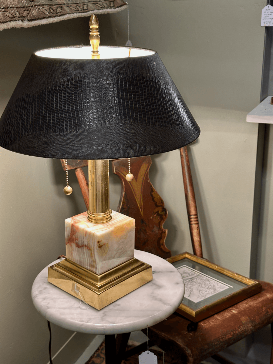 17 Fall-Ready Nashville FINDS: Cozy Layers, Beauty & Spooky Season Style - 18 A table lamp with a black shade and marble base, a Nashville finds October gem, sits on a round marble table beside a framed picture and wooden chair.