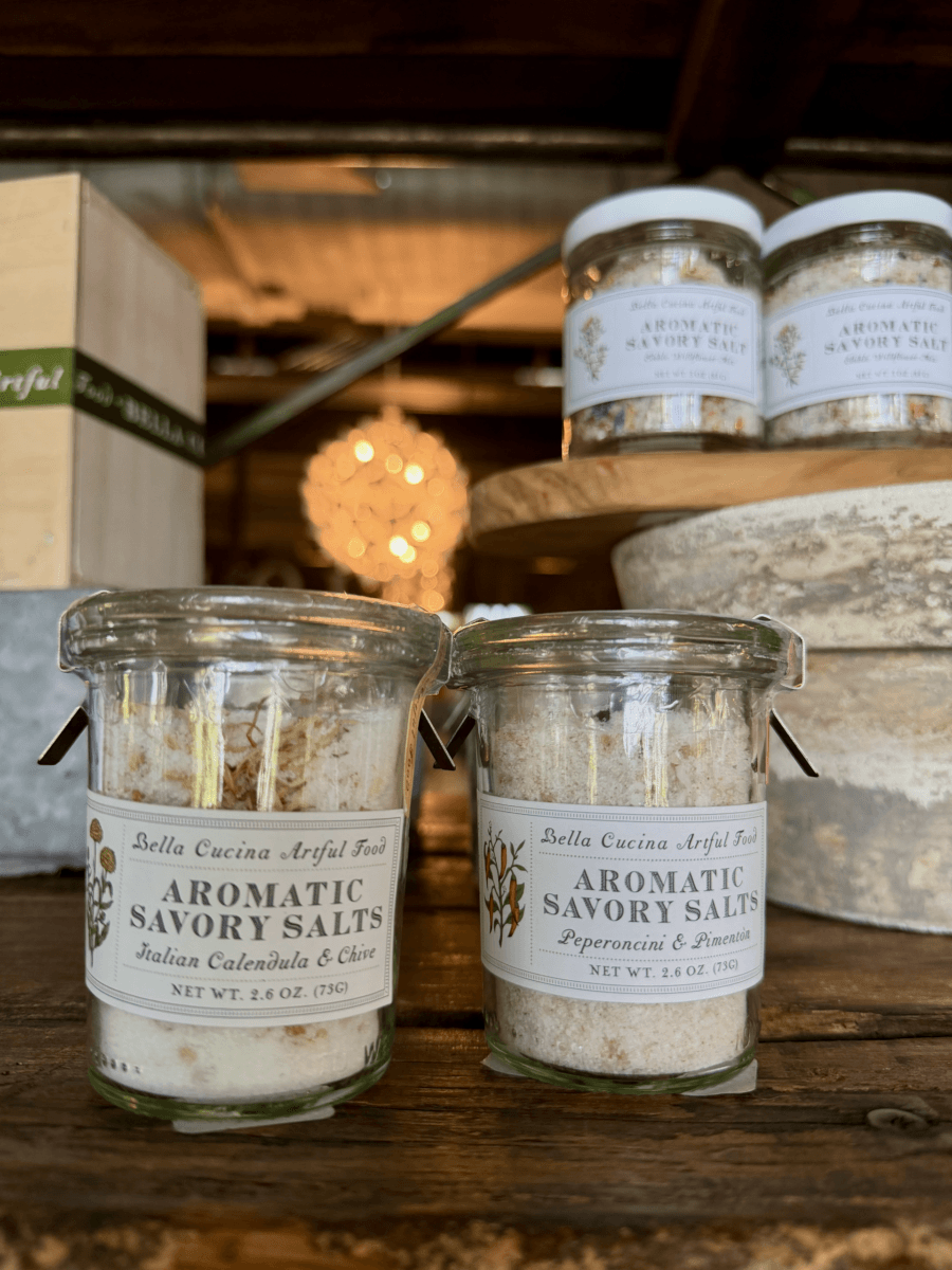 17 Fall-Ready Nashville FINDS: Cozy Layers, Beauty & Spooky Season Style - 11 Two glass jars of Bella Cucina Aromatic Savory Salts, a Nashville finds October favorite, are displayed on a wooden surface with blurred jars and decor in the background.