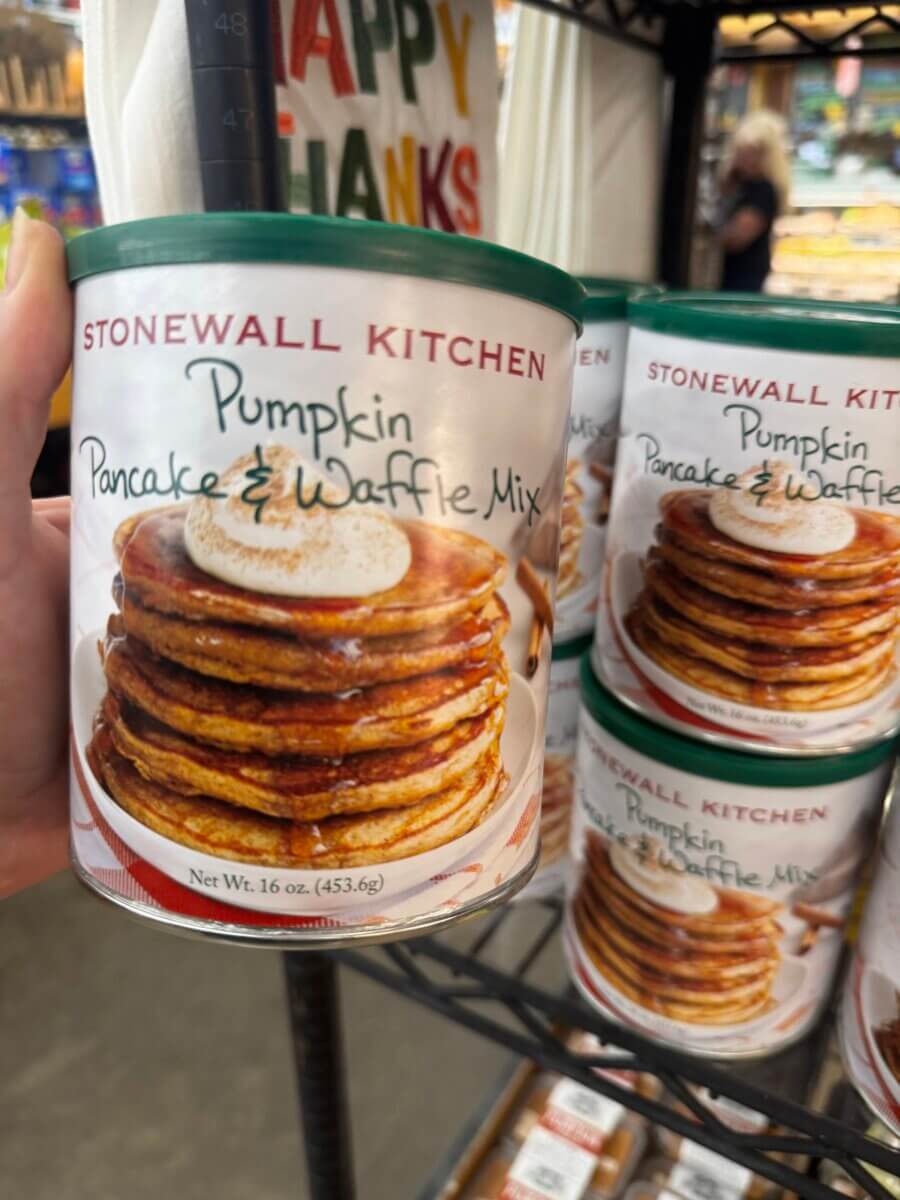 17 Louisville FINDS for October: Fall Fashion, Festive Decor & Game-Day Essentials - 11 A can of Stonewall Kitchen Pumpkin Pancake & Waffle Mix, a cozy find in Louisville, held in front of identical cans on a store shelf.