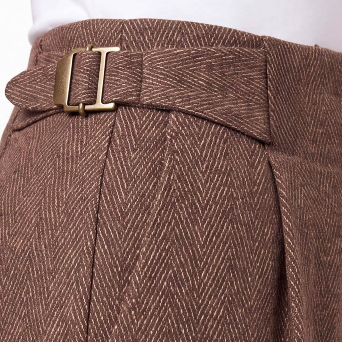 Louisville Fall Fashion 2026: 3 Runway Trends to Incorporate - 5 Close-up of brown herringbone-patterned trousers with a matching fabric belt and brass buckle, worn with a white top—a chic nod to fall fashion 2026.