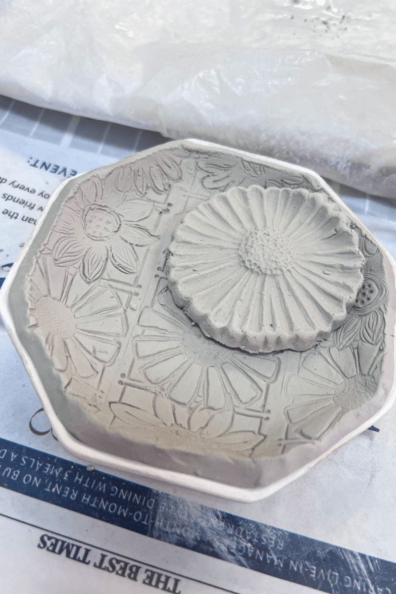 Create, Connect & Get a Little Messy at This Memphis Pottery Studio - 2 Round and octagonal pieces of clay with embossed floral patterns rest on a paper surface, inviting you to Create and Connect through every artistic imprint.