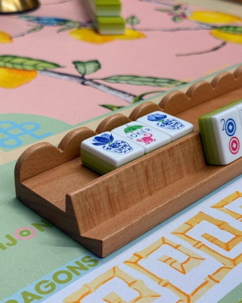 Your Ultimate Memphis Mahjong Guide - 6 A close-up of a mahjong tile rack holding four tiles, set on a colorful table with a lemon pattern, captures the lively spirit of Memphis Mahjong.