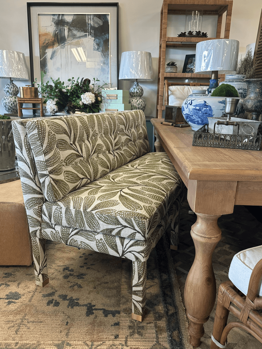 Green and white patterned bench at a wooden dining table, with decorative items, lamps, and framed artwork in the background—a charming Nashville FINDS feature for September.