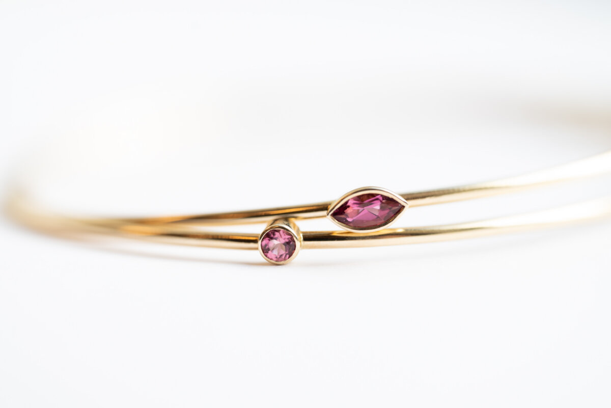 Nashville Steals, Deals & Announcements: October 2026 - 3 A gold bracelet featuring two pink gemstones, one round and one marquise-cut, against a white background.