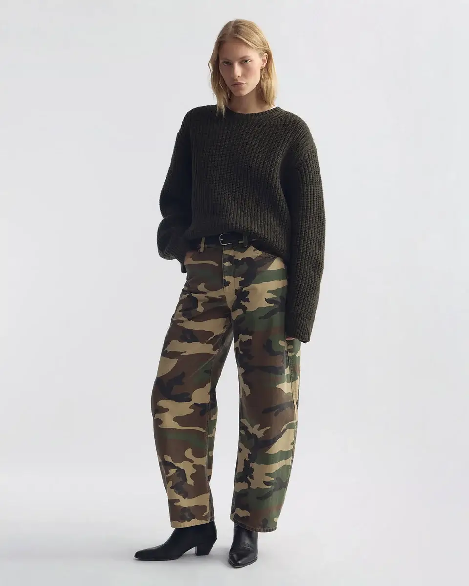 Person standing against a plain background, wearing a dark ribbed sweater, camouflage print pants, and black boots—perfectly capturing that effortlessly cool Nashville style for your September FINDS.