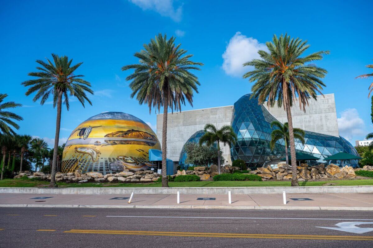 7 Southern Art Museums & Installations Worth Planning a Trip Around - 6 Modern glass and concrete building with a surrealist dome, surrounded by palm trees and a clear blue sky at The Dalí Museum.