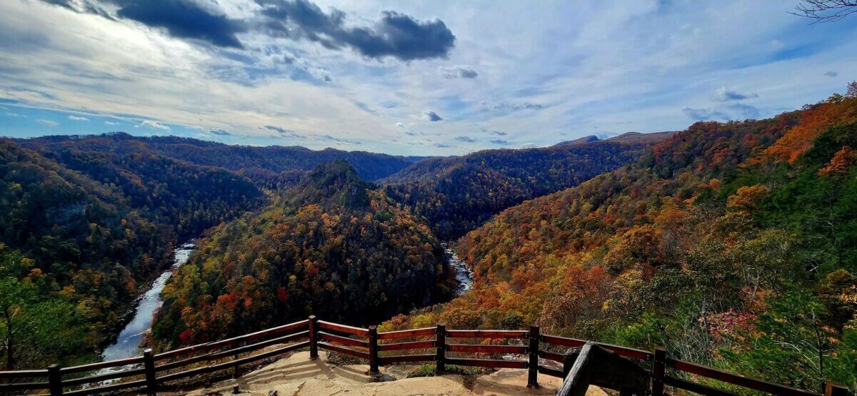5 NEW Hikes to Explore Around the South - 4 Wooden overlook deck facing a river winding through forested hills with autumn foliage at Breaks Interstate State Park.