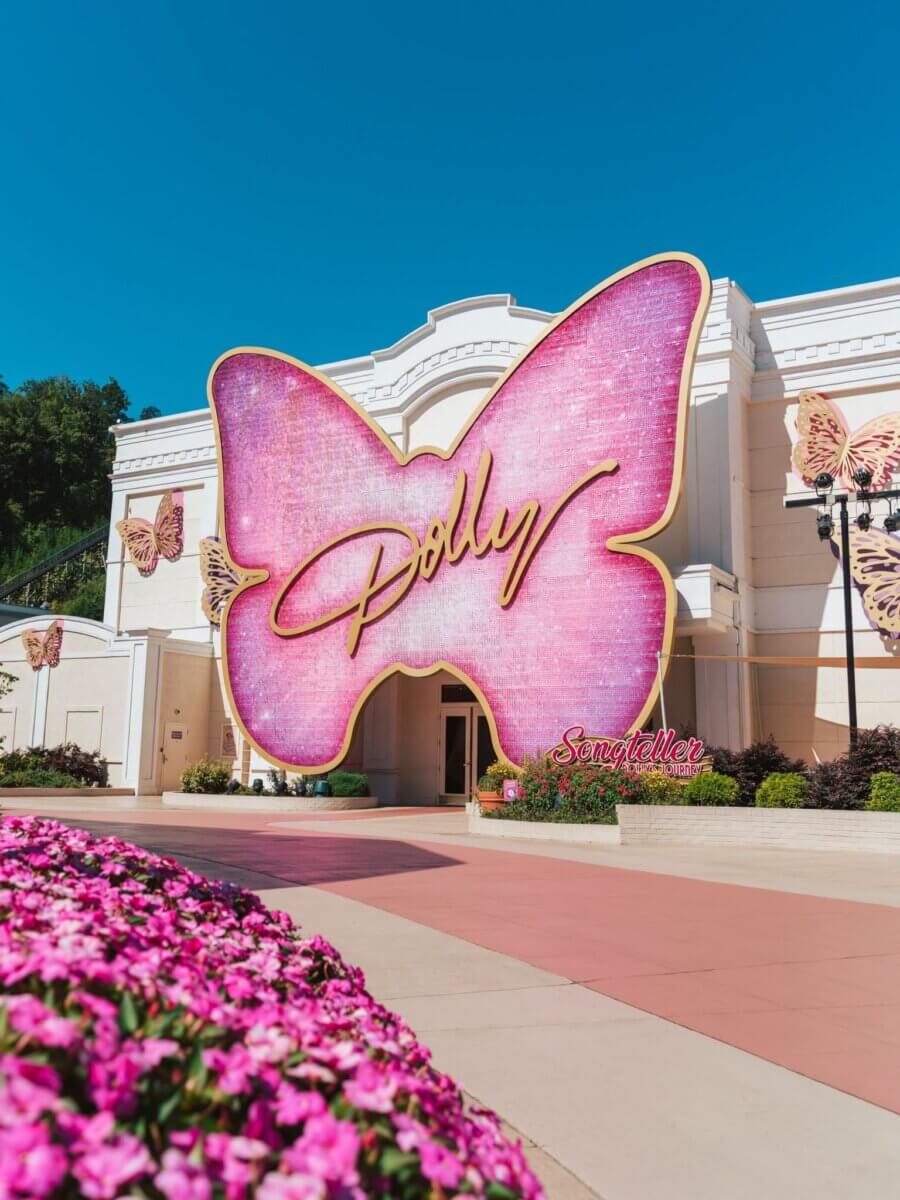For the Love of Dolly: 7 Ways to Celebrate Her Legacy - 6 A large butterfly-shaped sign reading “Dolly” decorates the entrance of the Dolly Experience in Dollywood.
