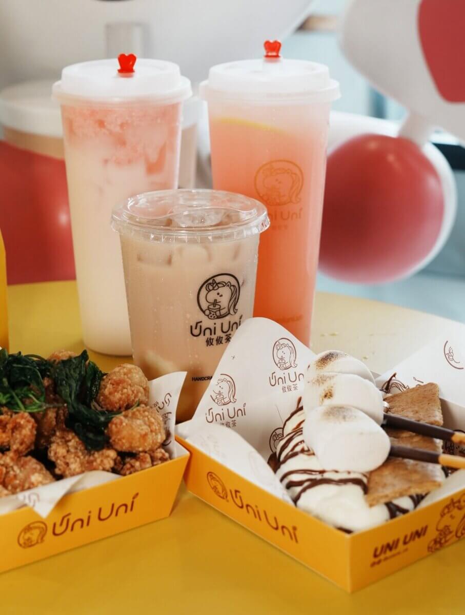 12 New Nashville Restaurants to Try This Month - 11 Three bubble tea drinks, a box of fried chicken, and a dessert with marshmallows, chocolate, and cookies are arranged on a yellow table—a tempting preview of what to expect at some of the exciting new restaurants opening in Nashville this September.