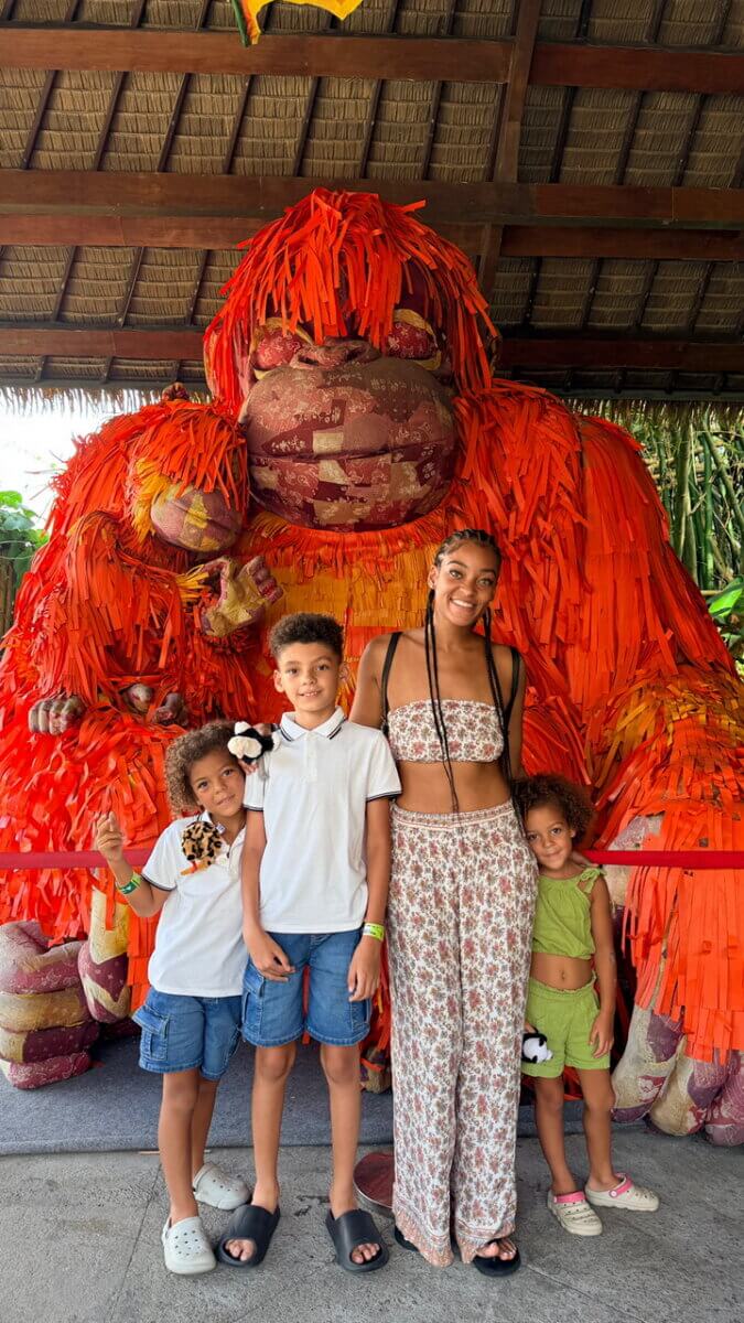 Southern Roots, Japanese Technique: Inside Chef Ashley Jackson's Johin'na - 2 A woman and three children stand before a large, decorative orange ape statue.