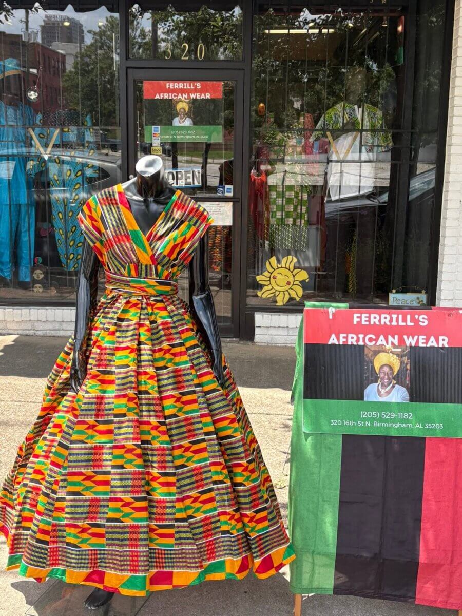 Your Guide to Birmingham's Historic 4th Avenue Historic District - 3 A mannequin wears a vibrant, kente-patterned dress in red, yellow, green, and black in front of Ferrill’s African Wear in Birmingham’s 4th Avenue District.
