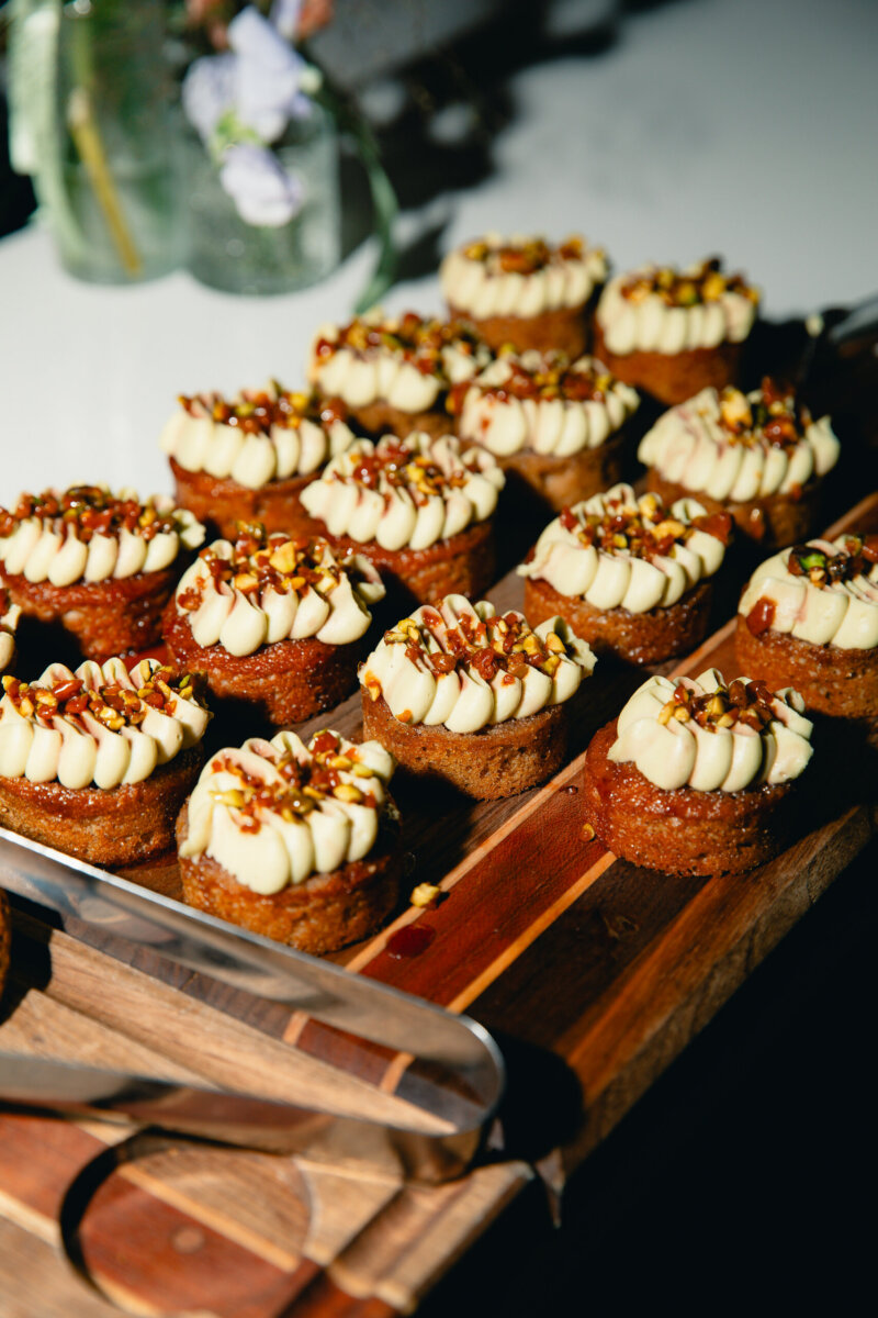 What Happens When You Bring 22 Birmingham Strangers Together and Say "Trust Me"? - 6 A wooden board holding small, round Hattie O’Hara cakes topped with piped frosting and chopped nuts, prepared for a Trust Me Night in Birmingham.