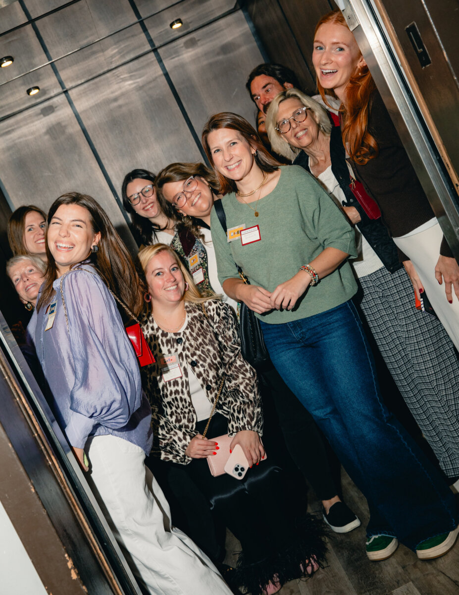 What Happens When You Bring 22 Birmingham Strangers Together and Say "Trust Me"? - 4 A group of nine people smiling together inside a Birmingham elevator during Trust Me Night.