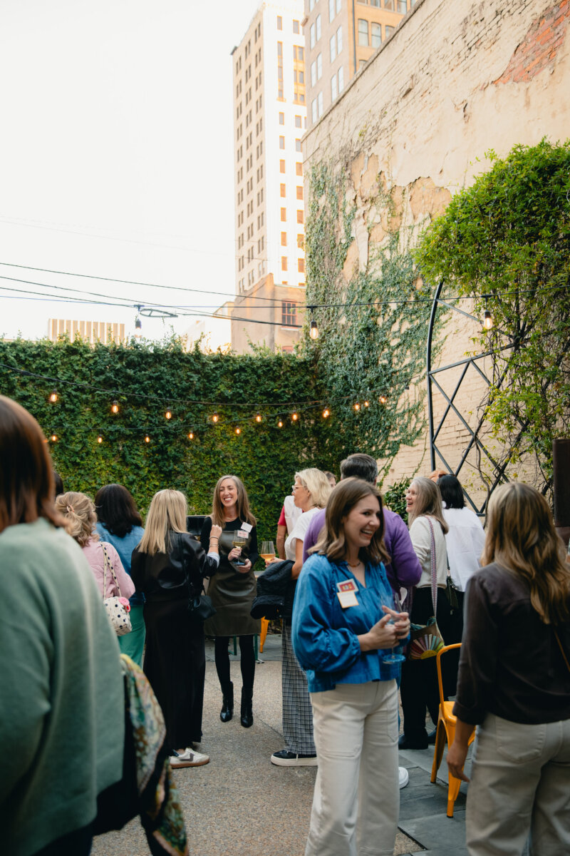 What Happens When You Bring 22 Birmingham Strangers Together and Say "Trust Me"? - 3 A group of people standing together in an outdoor courtyard decorated with string lights.
