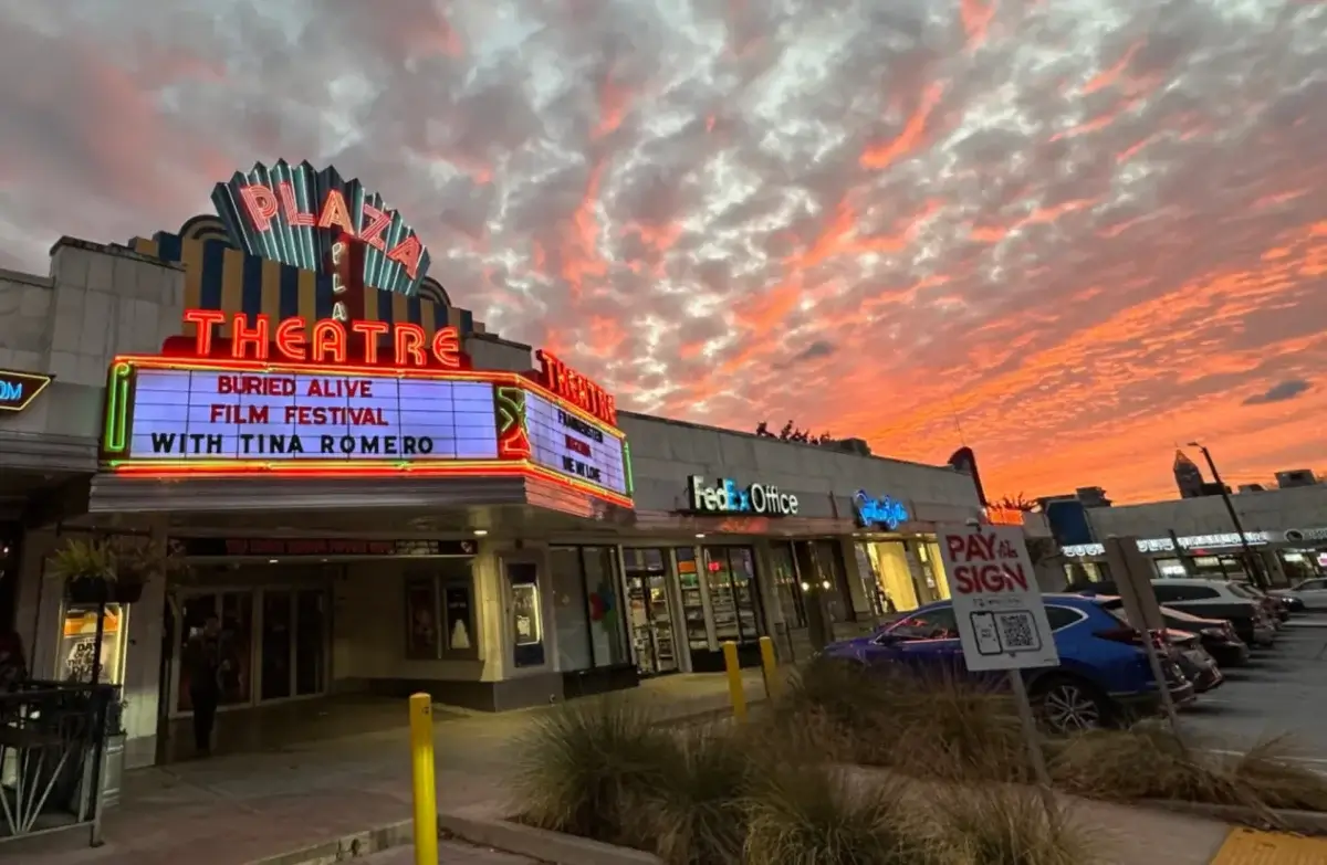 The Plaza Theatre marquee at sunset, advertising the Buried Alive Film Festival with Tina Romero, next to a FedEx Office.