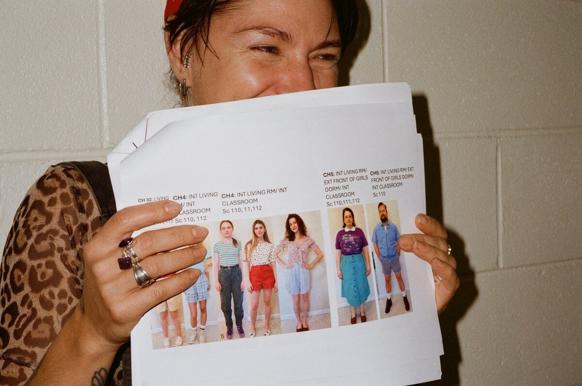 The Haunted Folklore of Mississippi Influenced This Costume Designer's Career - 5 A costume designer holds a printed casting sheet featuring photos of actors and their associated Mississippi scene locations.