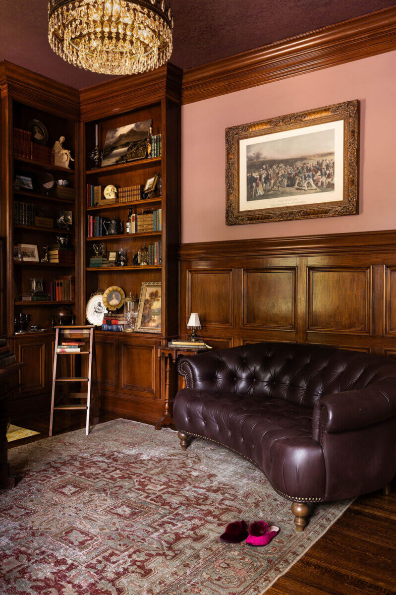 From ICU Nurse to Interior Designer: Meet Gretchen Rose of Kentucky Rose Designs - 3 A wood-paneled library showcasing Kentucky Rose Designs interior design, featuring floor-to-ceiling bookshelves, a tufted leather sofa, and a framed historical print on the wall.