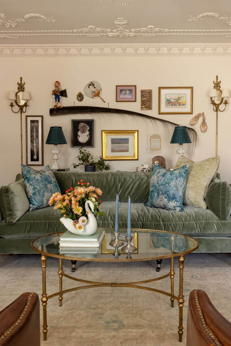 From ICU Nurse to Interior Designer: Meet Gretchen Rose of Kentucky Rose Designs - 10 A Gretchen Rose velvet sofa sits before a gallery wall featuring various framed art, a swan-shaped planter, and candles on a coffee table.