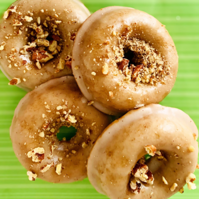 Bring These Apple Butter Donuts to Your Next Gathering and Become Everyone’s Favorite - 2 Four glazed donuts topped with chopped nuts on a green surface.