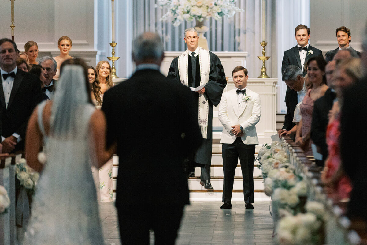 A Secret Speakeasy and Late-Night Taco Bell?! This Nashville Wedding Had Serious Surprises - 11 A bride walks down the aisle at a Nashville wedding toward the groom, who stands at the altar with an officiant and groomsmen.