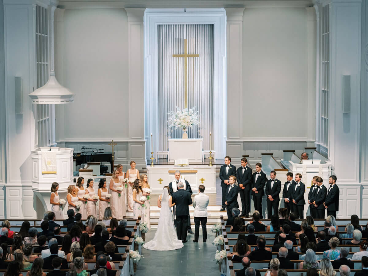 A Secret Speakeasy and Late-Night Taco Bell?! This Nashville Wedding Had Serious Surprises - 3 A bride and groom stand at the altar of a Nashville wedding ceremony, facing an officiant with the wedding party standing in rows to either side.