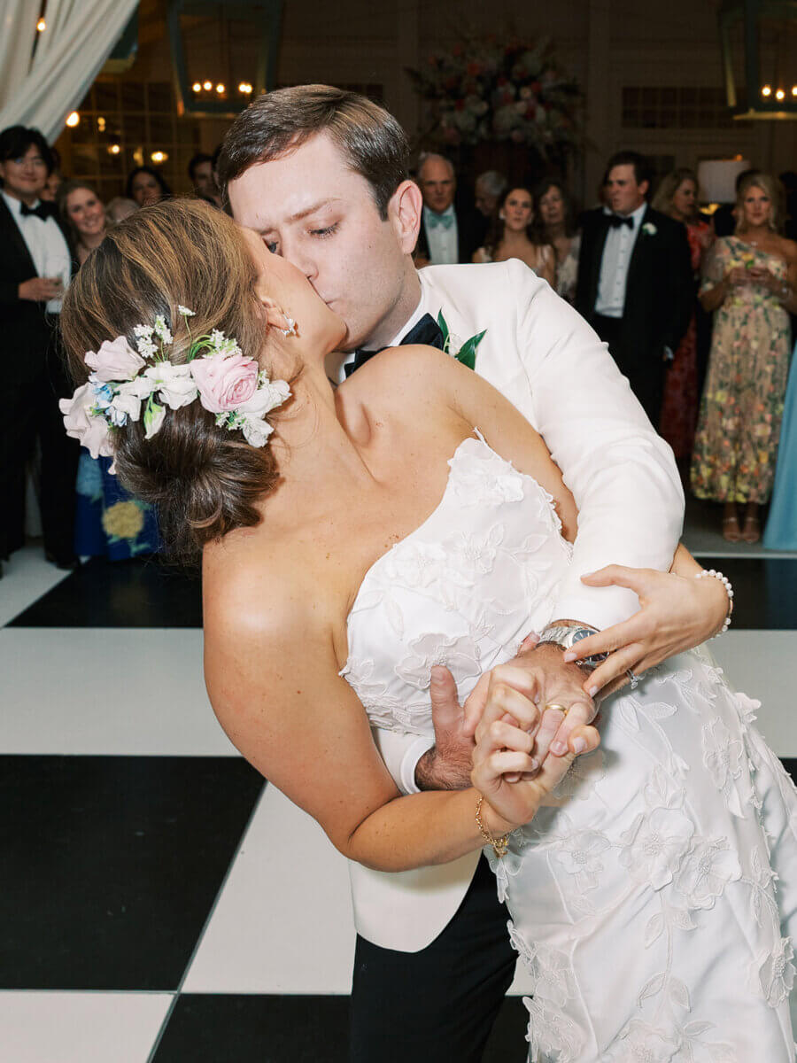 A Secret Speakeasy and Late-Night Taco Bell?! This Nashville Wedding Had Serious Surprises - 19 A bride and groom in formal wedding attire kiss while dancing on a black and white checkered floor at a Nashville wedding.