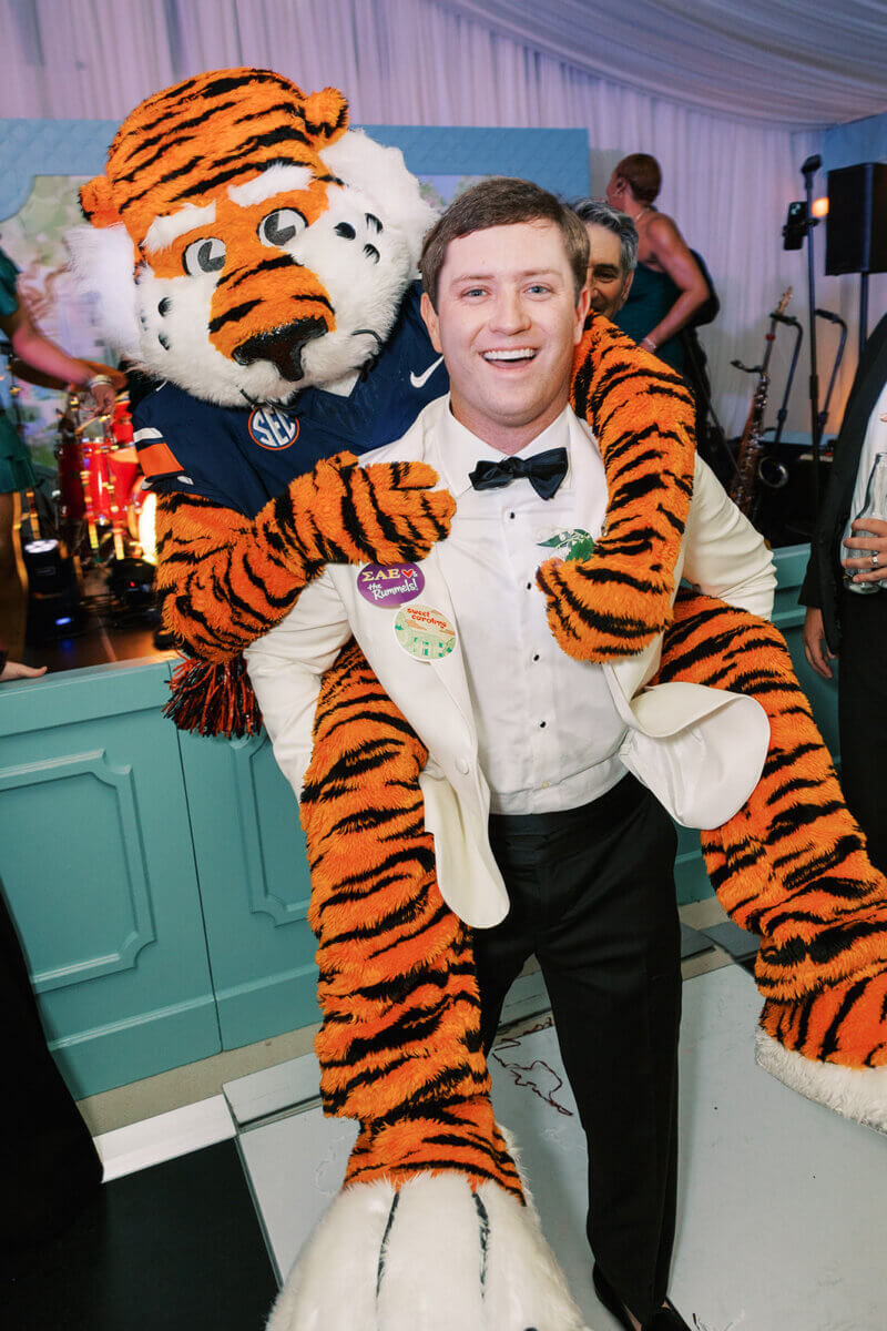 A Secret Speakeasy and Late-Night Taco Bell?! This Nashville Wedding Had Serious Surprises - 18 A man in a tuxedo gives a mascot tiger wearing an Auburn football jersey a piggyback ride at a Nashville wedding.