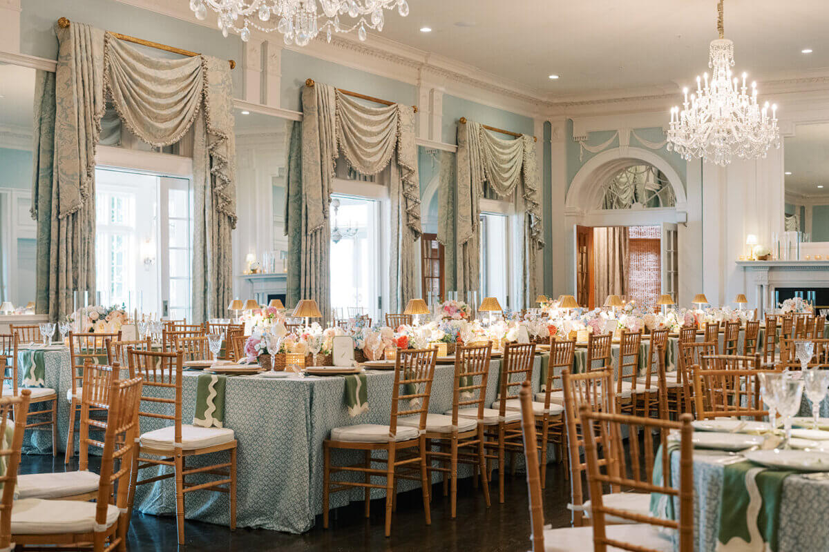 A Secret Speakeasy and Late-Night Taco Bell?! This Nashville Wedding Had Serious Surprises - 13 A long banquet table set for a Nashville wedding in a room with light blue walls, crystal chandeliers, and floor-to-ceiling drapery.