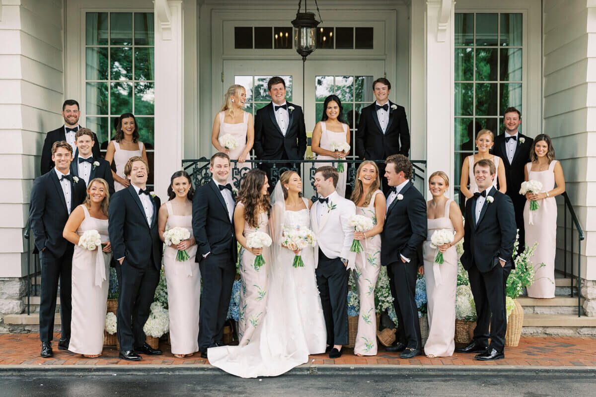 A Secret Speakeasy and Late-Night Taco Bell?! This Nashville Wedding Had Serious Surprises - 10 A large wedding party poses for a formal garden party wedding portrait in front of a building entrance.