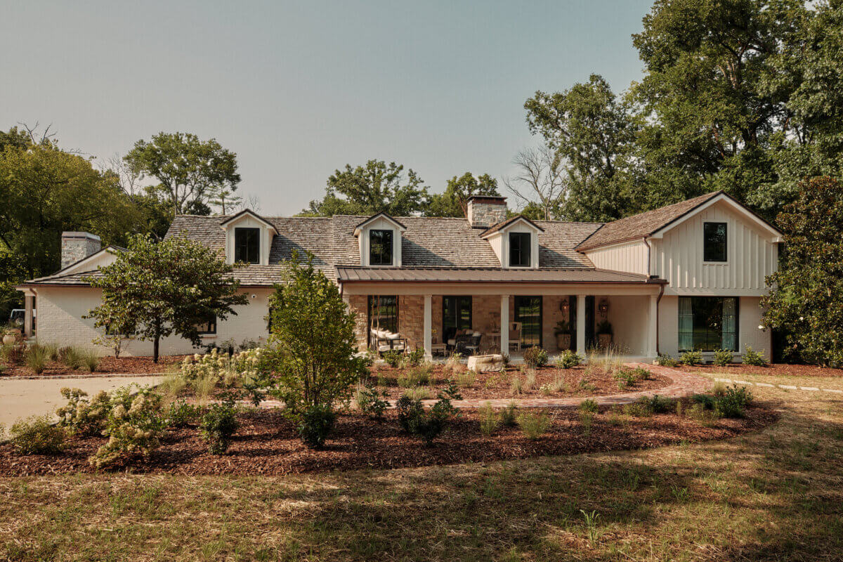 They Abandoned Their Dream Home Plans. Here's What Happened Next. - 17 A single-story ranch house with stone and white siding, a covered front porch, and a landscaped yard.
