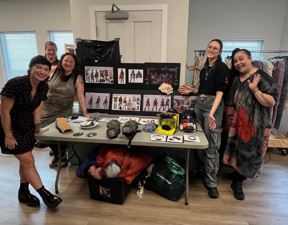 The Haunted Folklore of Mississippi Influenced This Costume Designer's Career - 8 The writer-director and costume designer stand with three others around a table displaying character sketches, protective gear, and accessories.