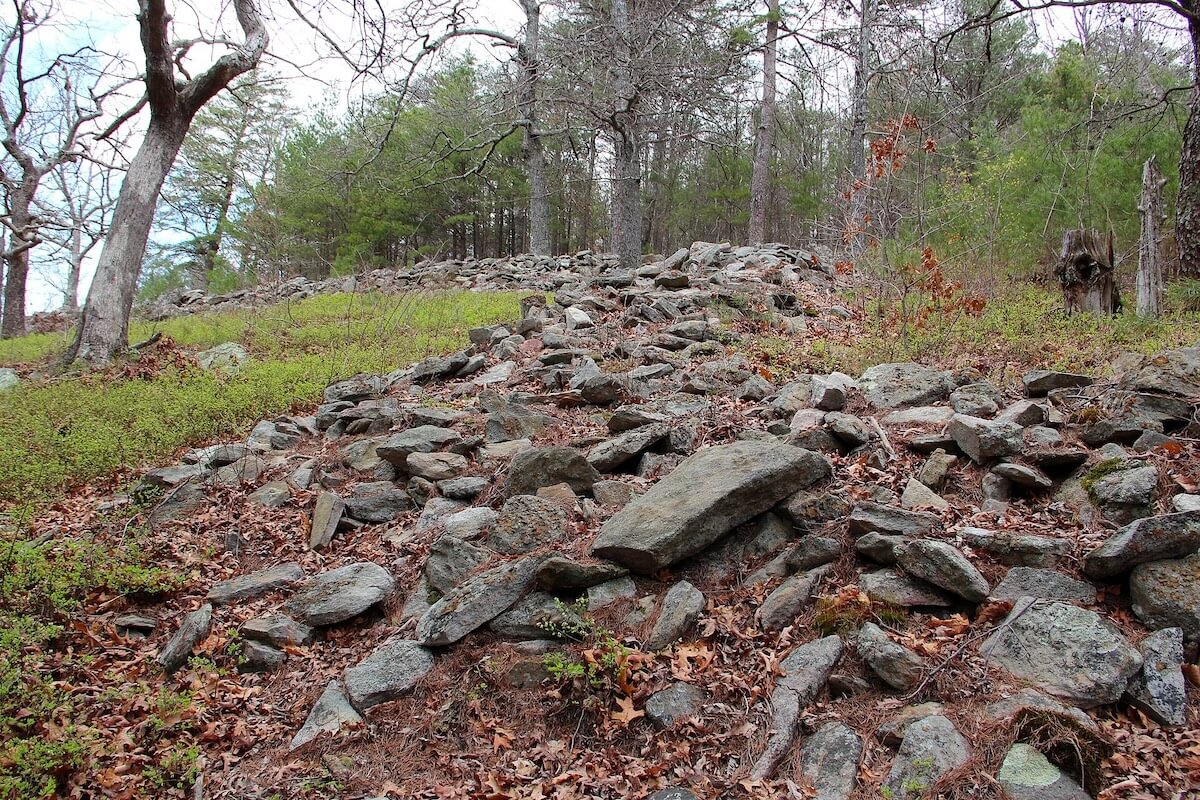7 Spooky Southern Legends That'll Make You Lock Your Door Tonight - 4 An old stone wall with a touch of Southern folklore runs up a spooky, leaf-covered hillside.